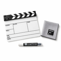 A film clapperboard with a black-and-white striped top, shown with a gray microfiber cleaning cloth and a FILMSTICKS marker on a clean white background.